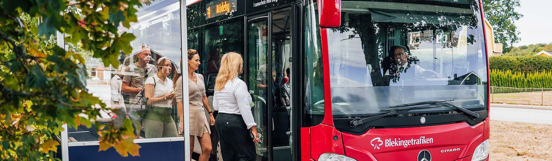 En grupp resenärer går ombord på en buss.