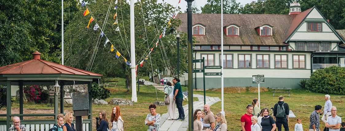 Personer står på Karön och väntar på båten