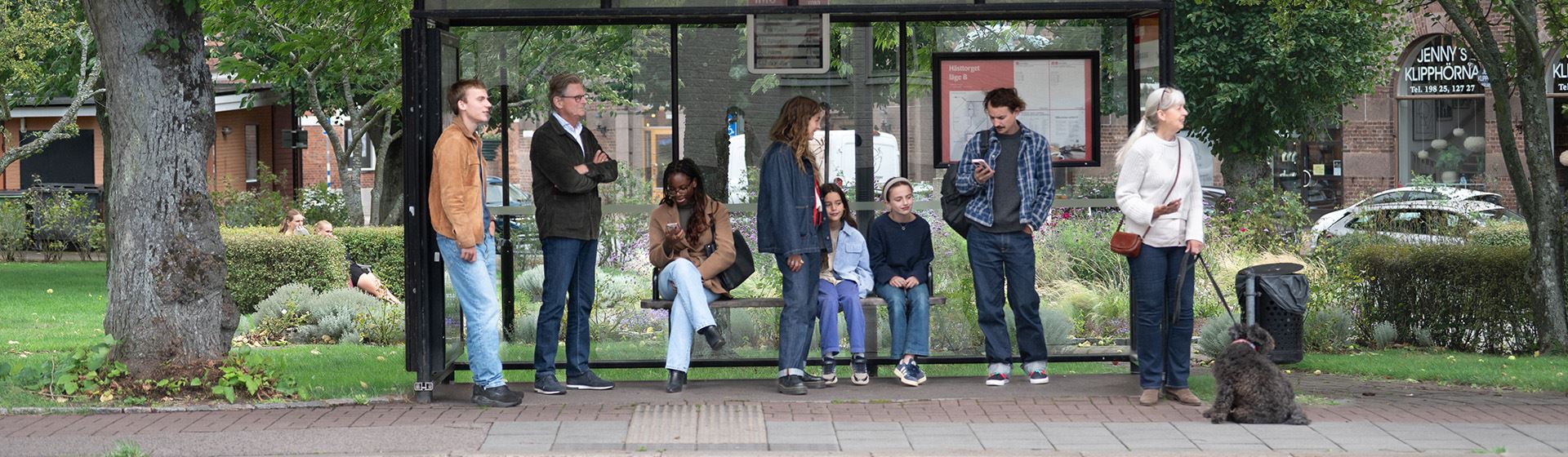 Flera resenärer väntar på bussen.