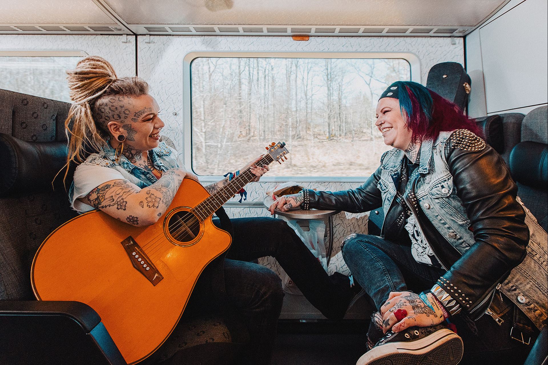 Två tjejer med tatuering sitter ombord på ett Öresundståg.