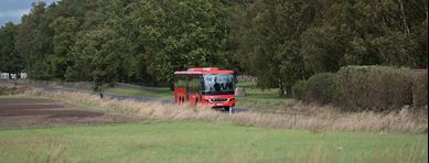 Buss i grönt landskap.