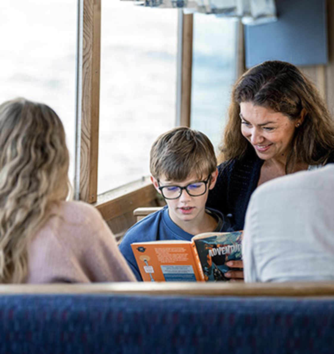 Kvinna läser bok tillsammans med ett barn.