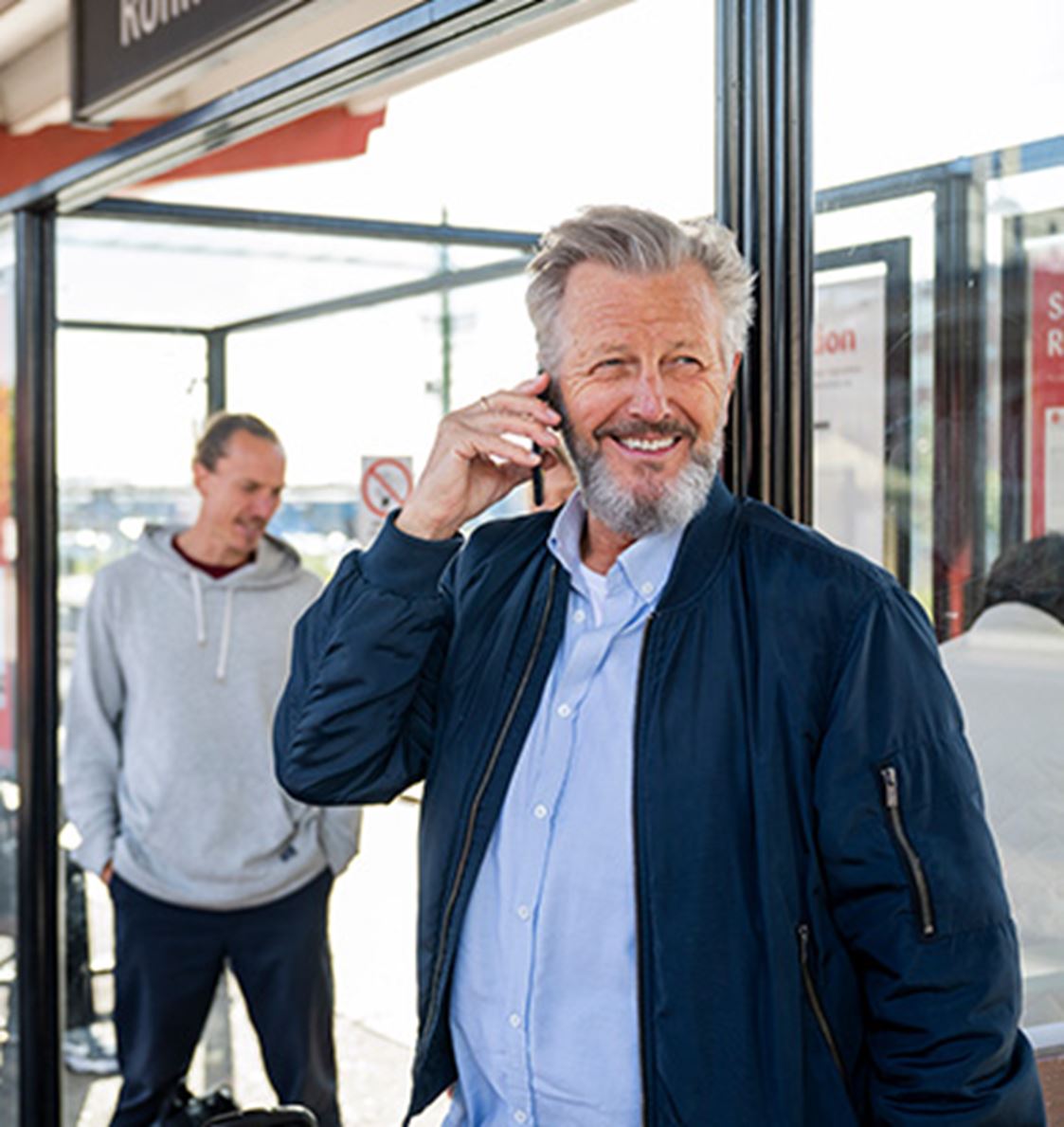 Man pratar i telefon på en perrong.