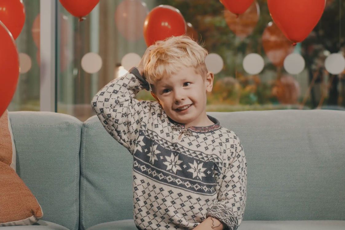 Ett barn sitter i en soffa.