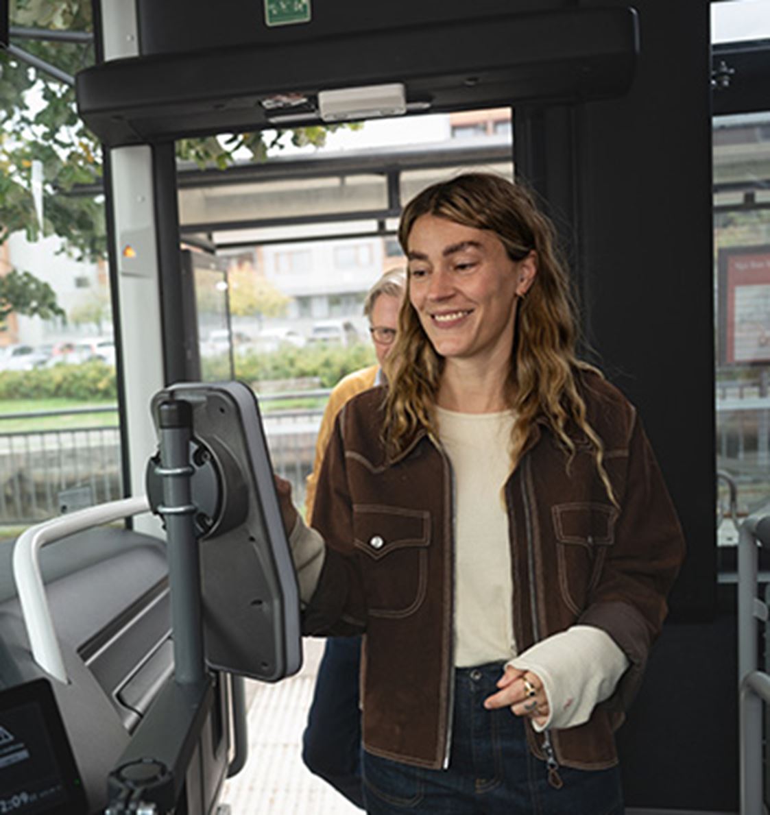 Ett kvinna blippar sin biljett på bussen.