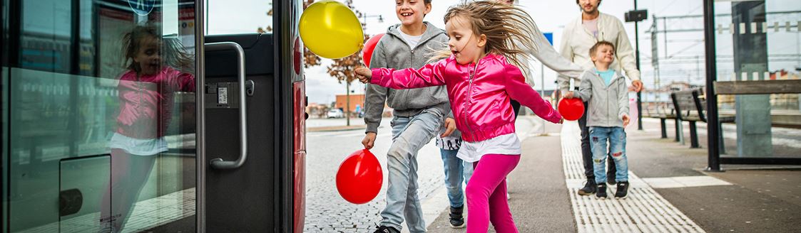 Barn med ballonger springer ombord på buss