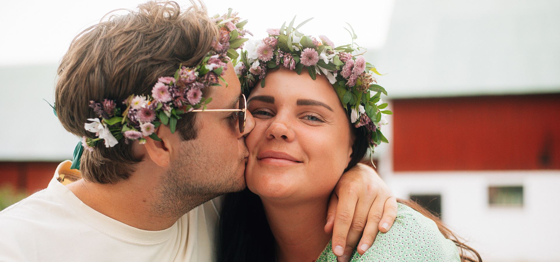 Man och kvinna med blomsterkransar i håret. 