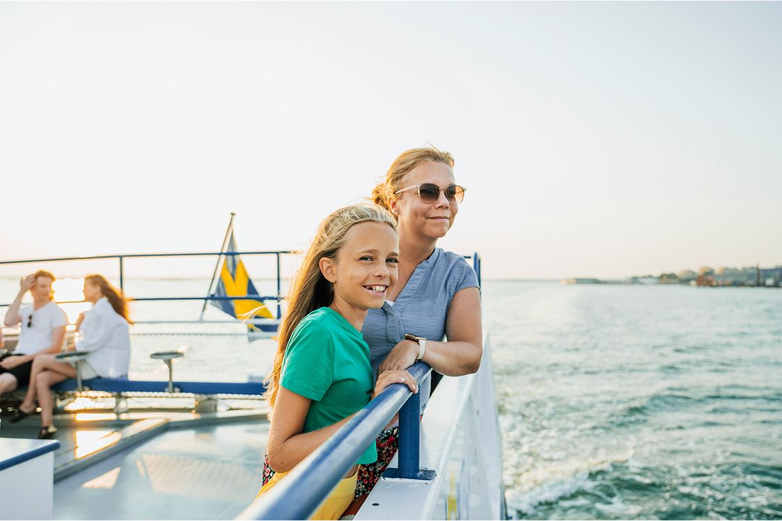 Två personer åker båt och tittar ut över havet.