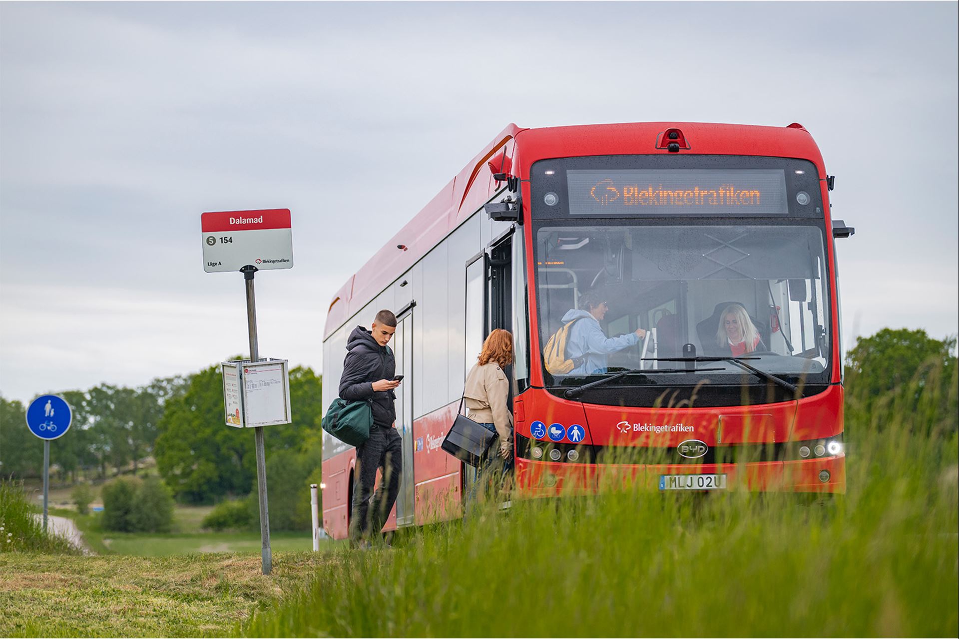 En buss som stanna vid en hållplats för att plocka upp resenärer.