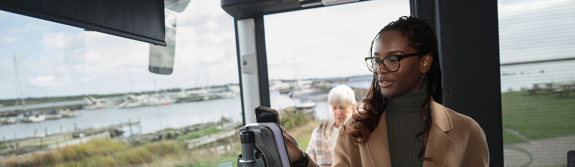 Kvinna blippar sin biljett på bussen.