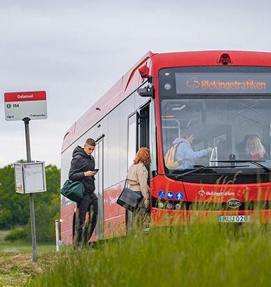 En ung man förbereder sig på att visa sin biljett i appen när han går ombord på bussen.
