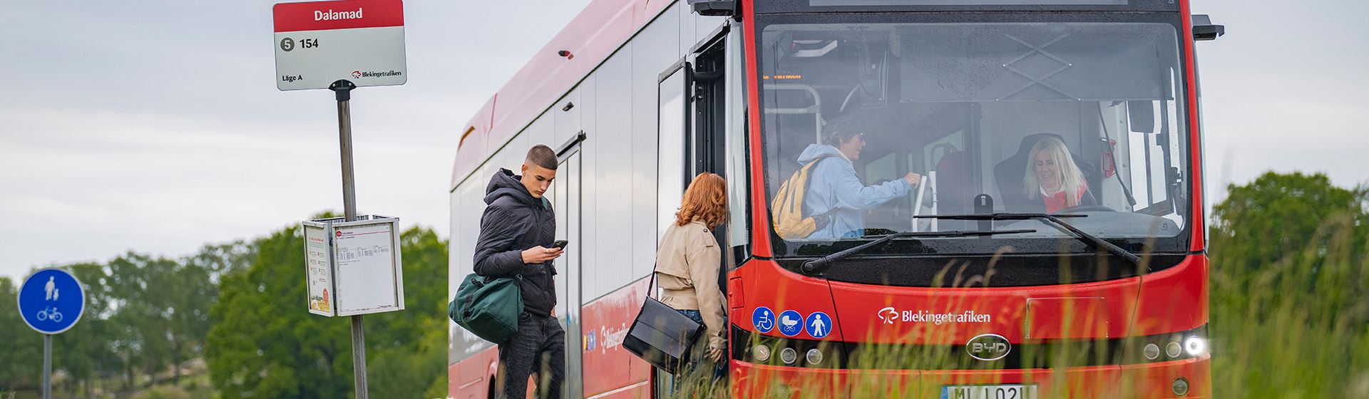 En ung man förbereder sig på att visa sin biljett i appen när han går ombord på bussen.