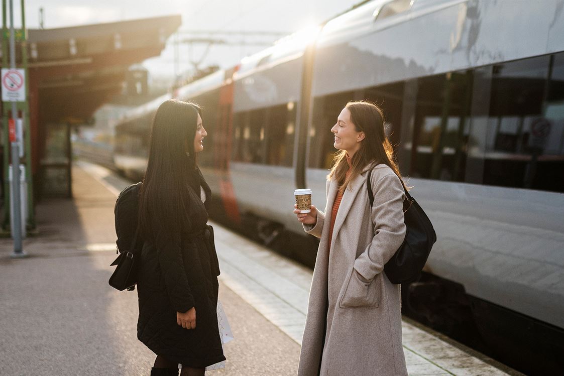Två kvinnor i samtal framför Öresundståg