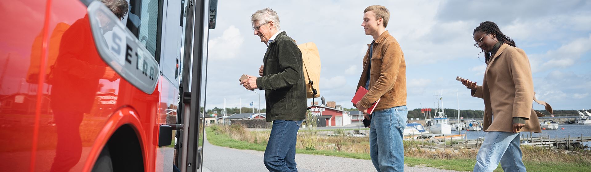 Personer som står i kö till bussen. 