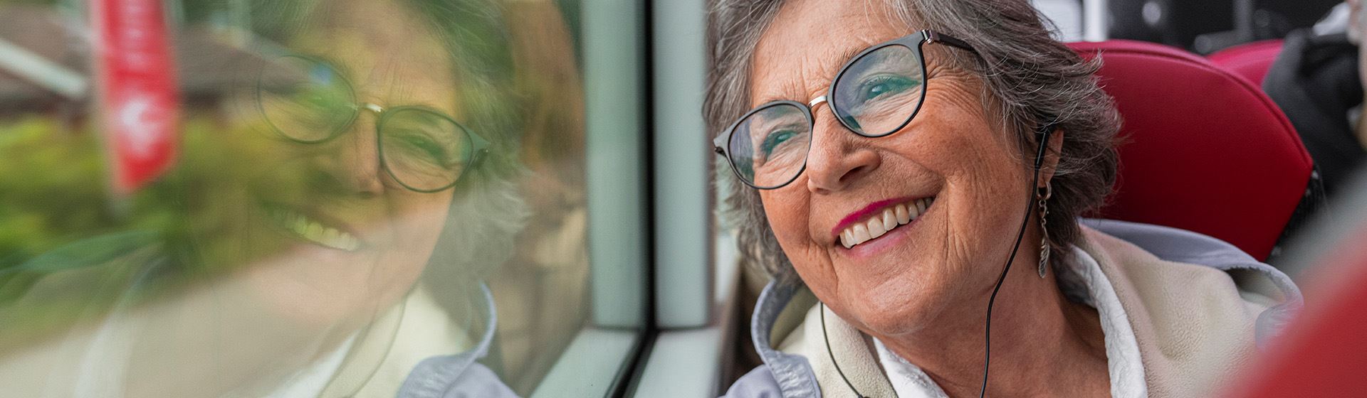 En kvinna tittar ut genom bussfönstret.