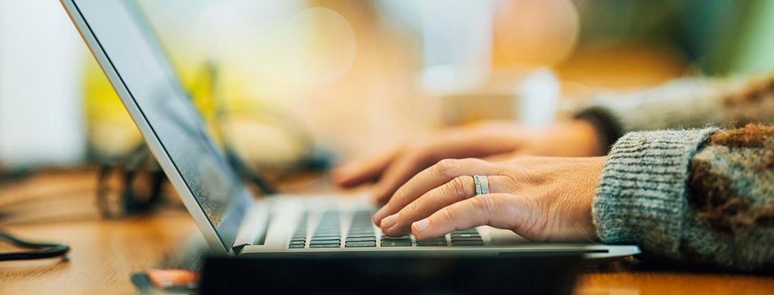 En hand ligger ovanpå en dators tangentbord.