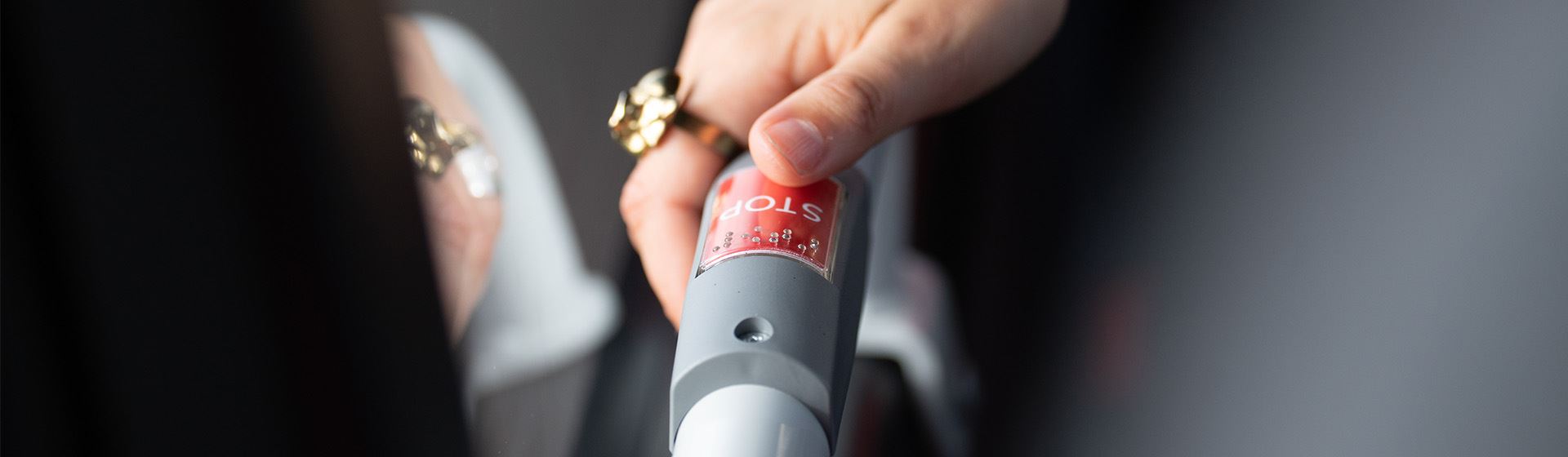 En hand trycker på en knapp med ordet "stop".