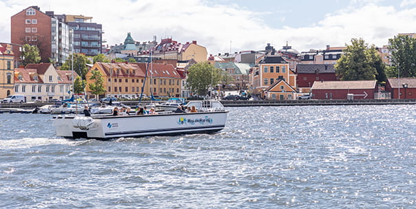 Båten M/F Annaskär i skärgården. Två personer sitter längst fram i båten.