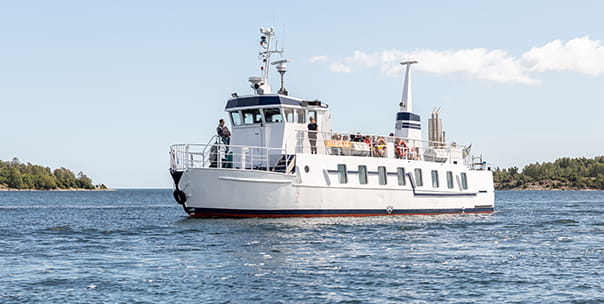 Båten M/F Vindskär. Båtens passagerare sitter på soldäck.