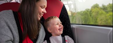 Förälder och barn tittar ut genom fönstret på bussen.