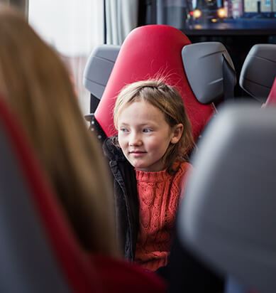 En flicka sitter på en buss.