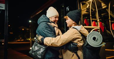 Två personer i mörker framför en buss.